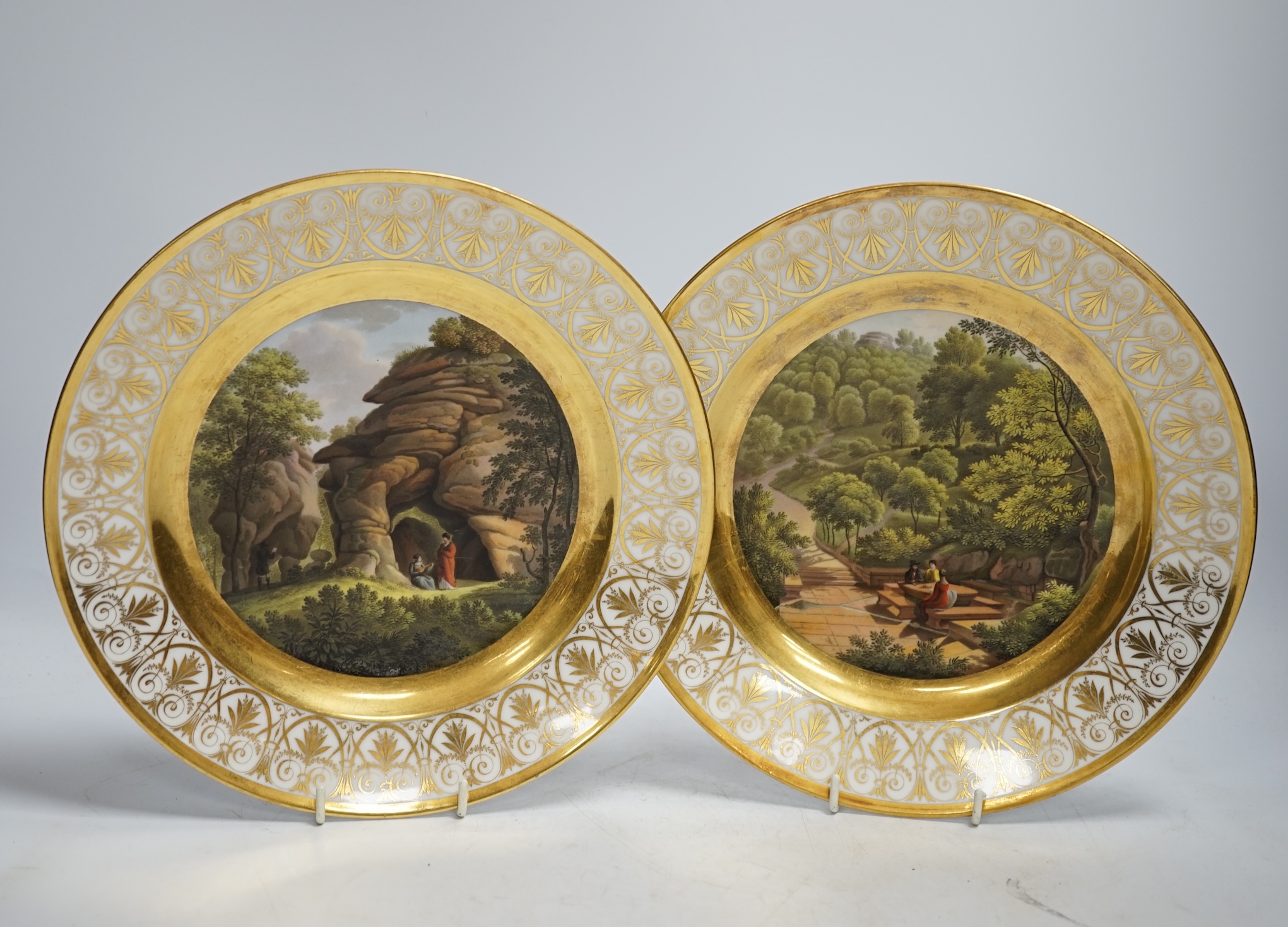 A pair of early 19th century Paris porcelain titled landscape and gilt decorated dishes, 24.5cm diameter